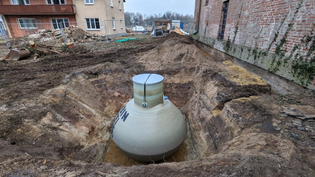 Abgesetzt und bereit zum Verfüllen, wartet der Erdtank in der Grube.